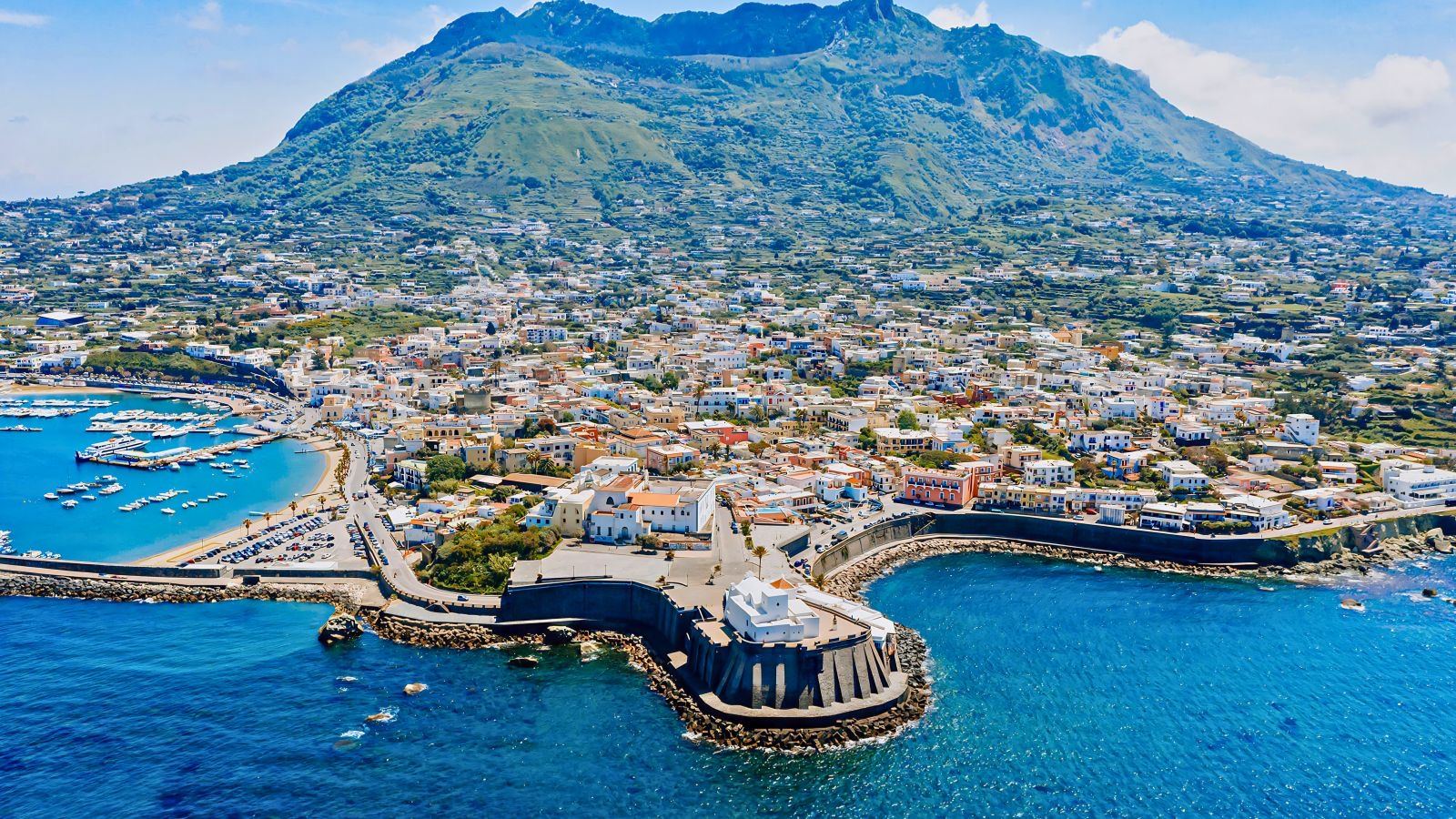 Forio d'Ischia vista aerea: il borgo bianco con il porto, le barche e il Monte Epomeo sullo sfondo