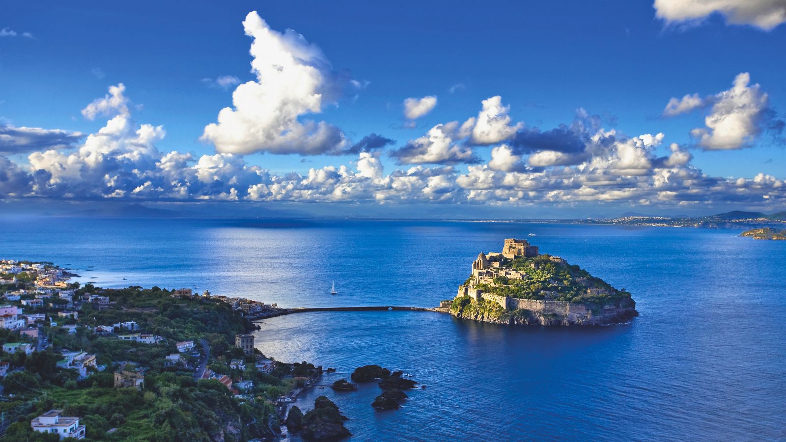 Castello Aragonese di Ischia Porto visto dall'alto: l'isola rocciosa con il castello medievale nel mare blu profondo del Golfo di Napoli